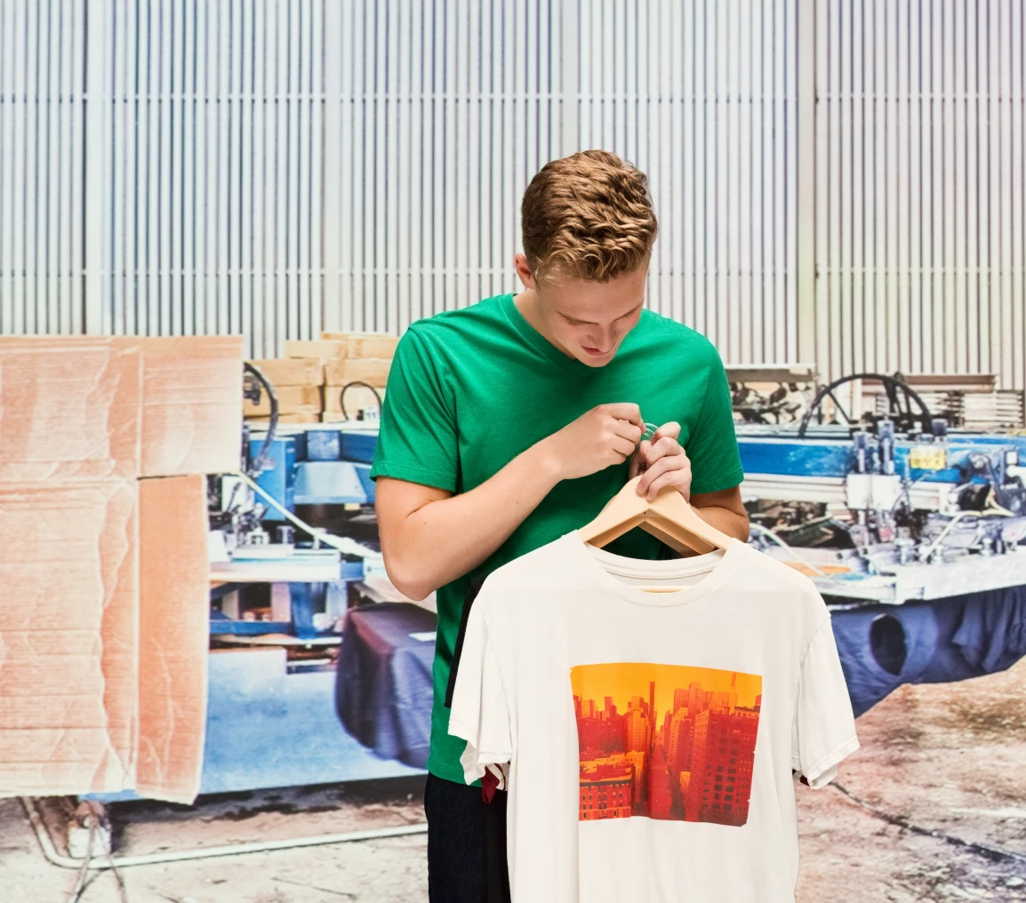 Man examining printed T-shirt in workshop